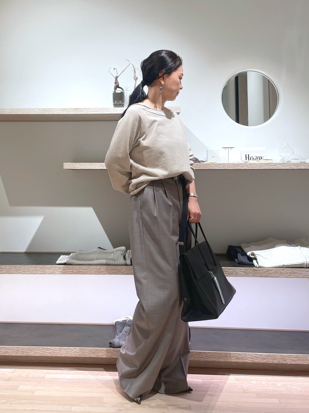 ベージュ系のスウェット、イエロー系のパンプス、ブラック系のボストンバッグを着用したレディースの春コーディネートの5枚目の写真