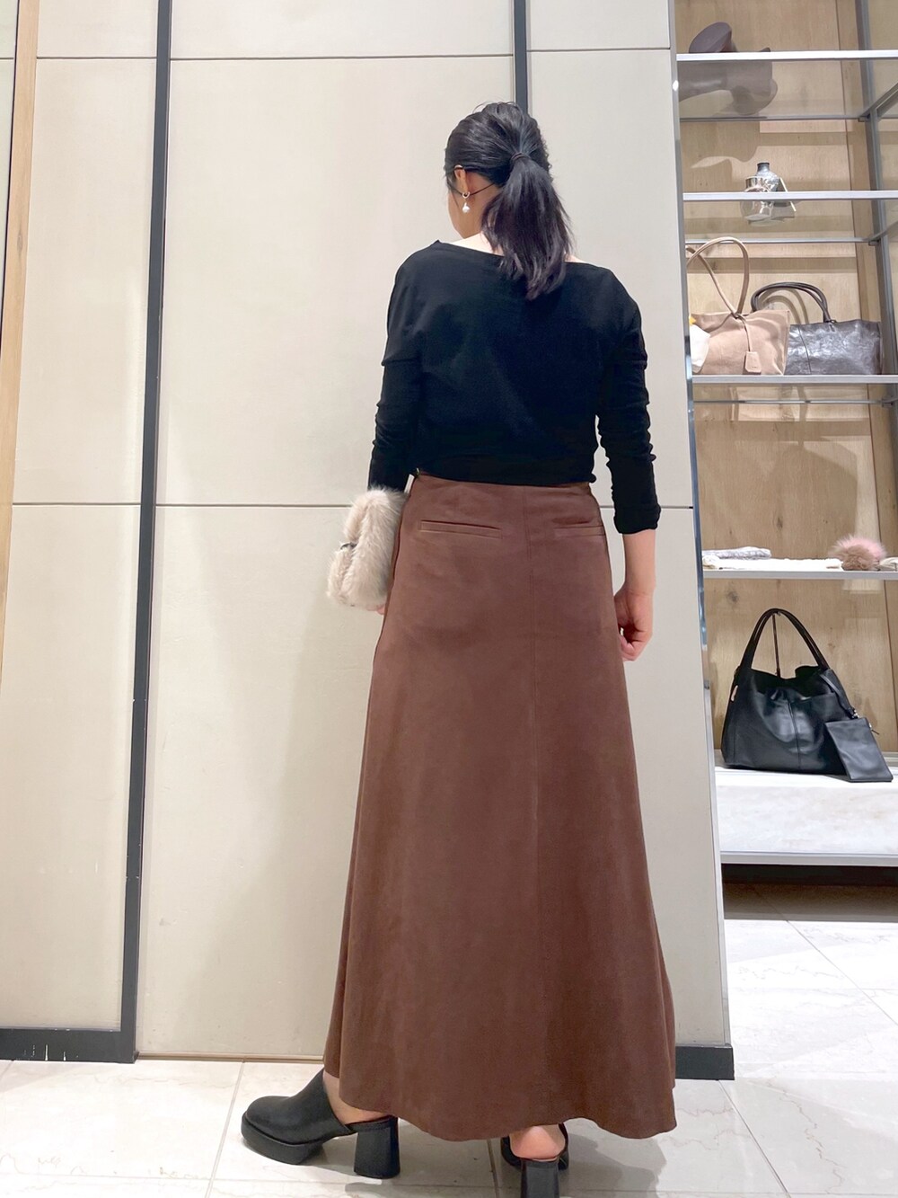 ブラック系のブーツ、ブラウン系のトートバッグ、ブラック系のTシャツ/カットソーを着用したレディースの秋コーディネートの3枚目の写真