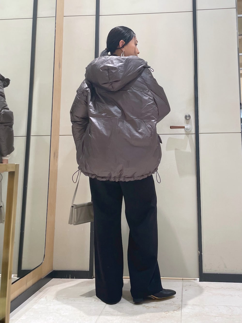 ブラック系のその他パンツ、ホワイト系のニット/セーター、ブラウン系のダウンジャケット/コートを着用したレディースの秋コーディネートの2枚目の写真