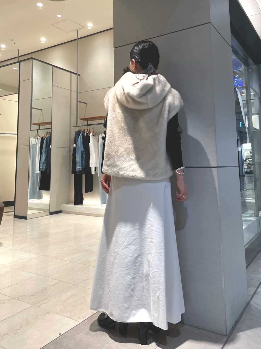 ベージュ系のスカート、ブラック系のブーツ、ブラック系のニット/セーターを着用したレディースの秋コーディネートの7枚目の写真