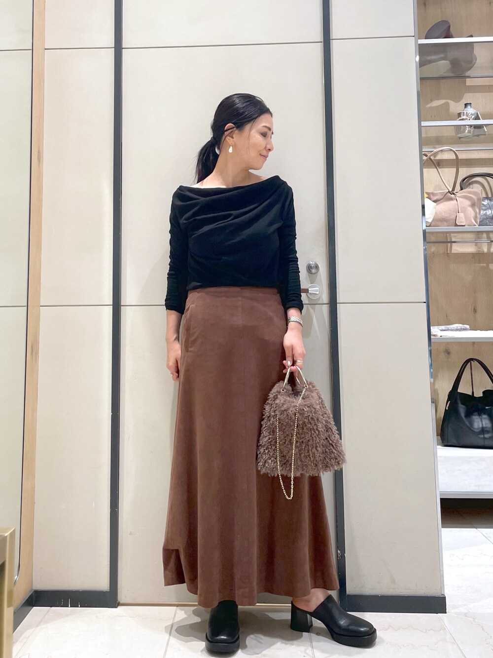 ブラック系のブーツ、ブラウン系のトートバッグ、ブラック系のTシャツ/カットソーを着用したレディースの秋コーディネートの6枚目の写真