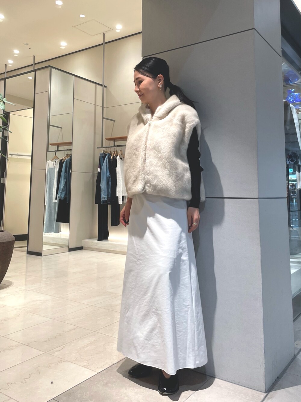 ベージュ系のスカート、ブラック系のブーツ、ブラック系のニット/セーターを着用したレディースの秋コーディネートの9枚目の写真