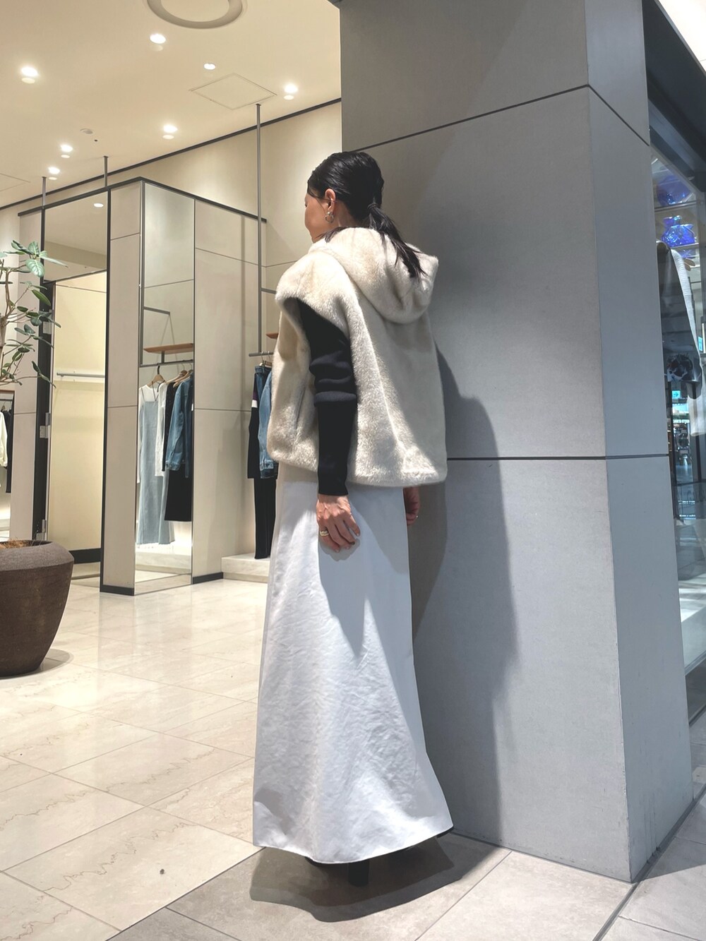 ベージュ系のスカート、ブラック系のブーツ、ブラック系のニット/セーターを着用したレディースの秋コーディネートの10枚目の写真