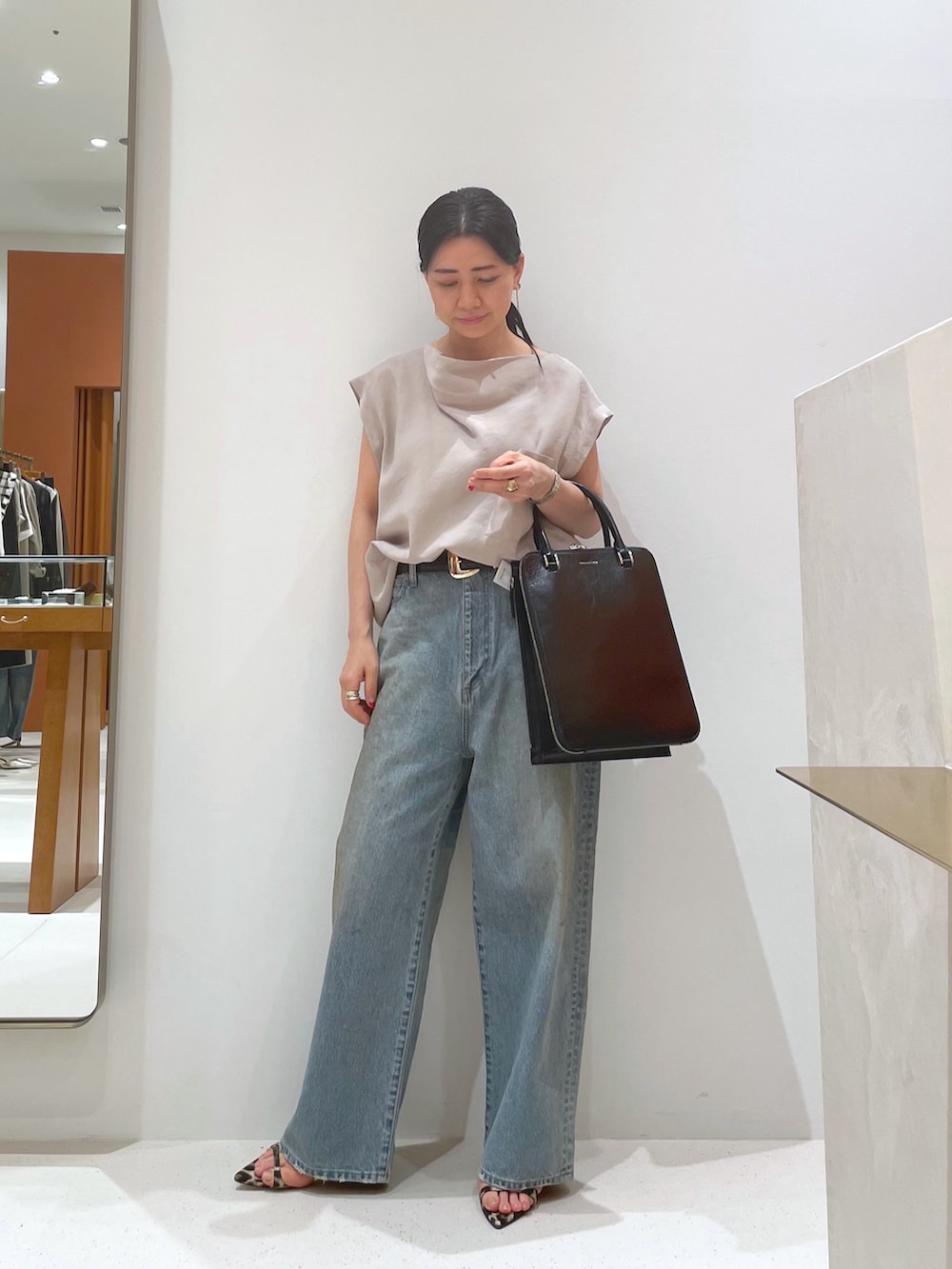 イエロー系のサンダル、ベージュ系のシャツ/ブラウス、ブルー系のデニムパンツを着用したレディースの夏コーディネートの4枚目の写真