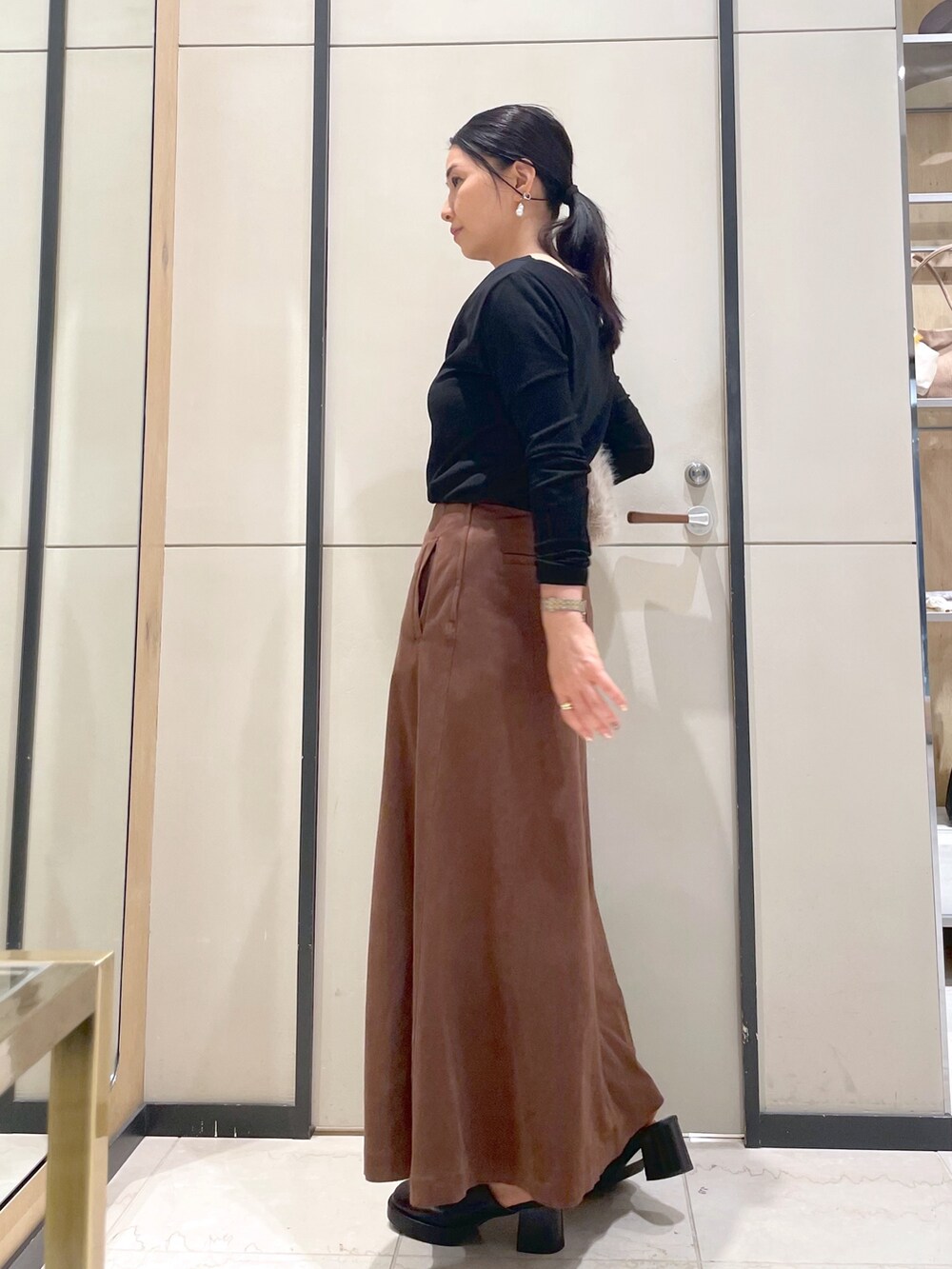 ブラック系のブーツ、ブラウン系のトートバッグ、ブラック系のTシャツ/カットソーを着用したレディースの秋コーディネートの8枚目の写真