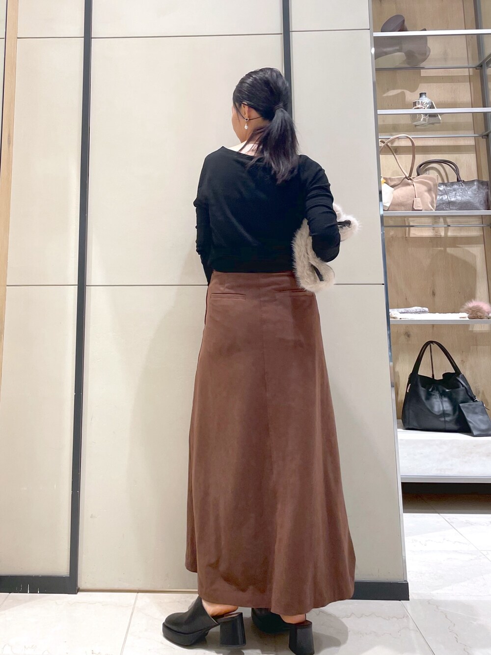 ブラック系のブーツ、ブラウン系のトートバッグ、ブラック系のTシャツ/カットソーを着用したレディースの秋コーディネートの7枚目の写真