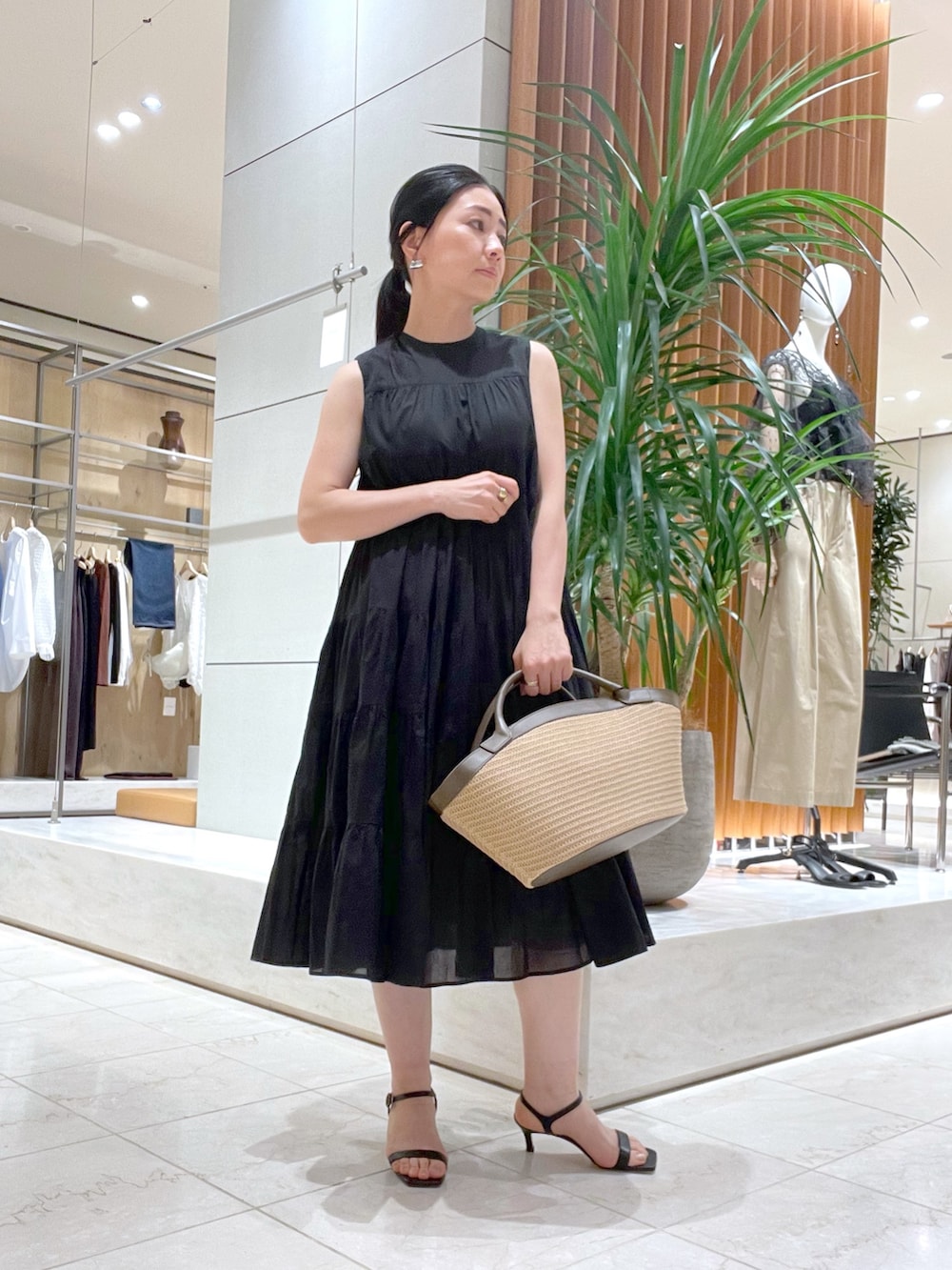 ブラック系のワンピース、ブラック系のサンダル、ブルー系のシャツ/ブラウスを着用したレディースの春コーディネートの8枚目の写真