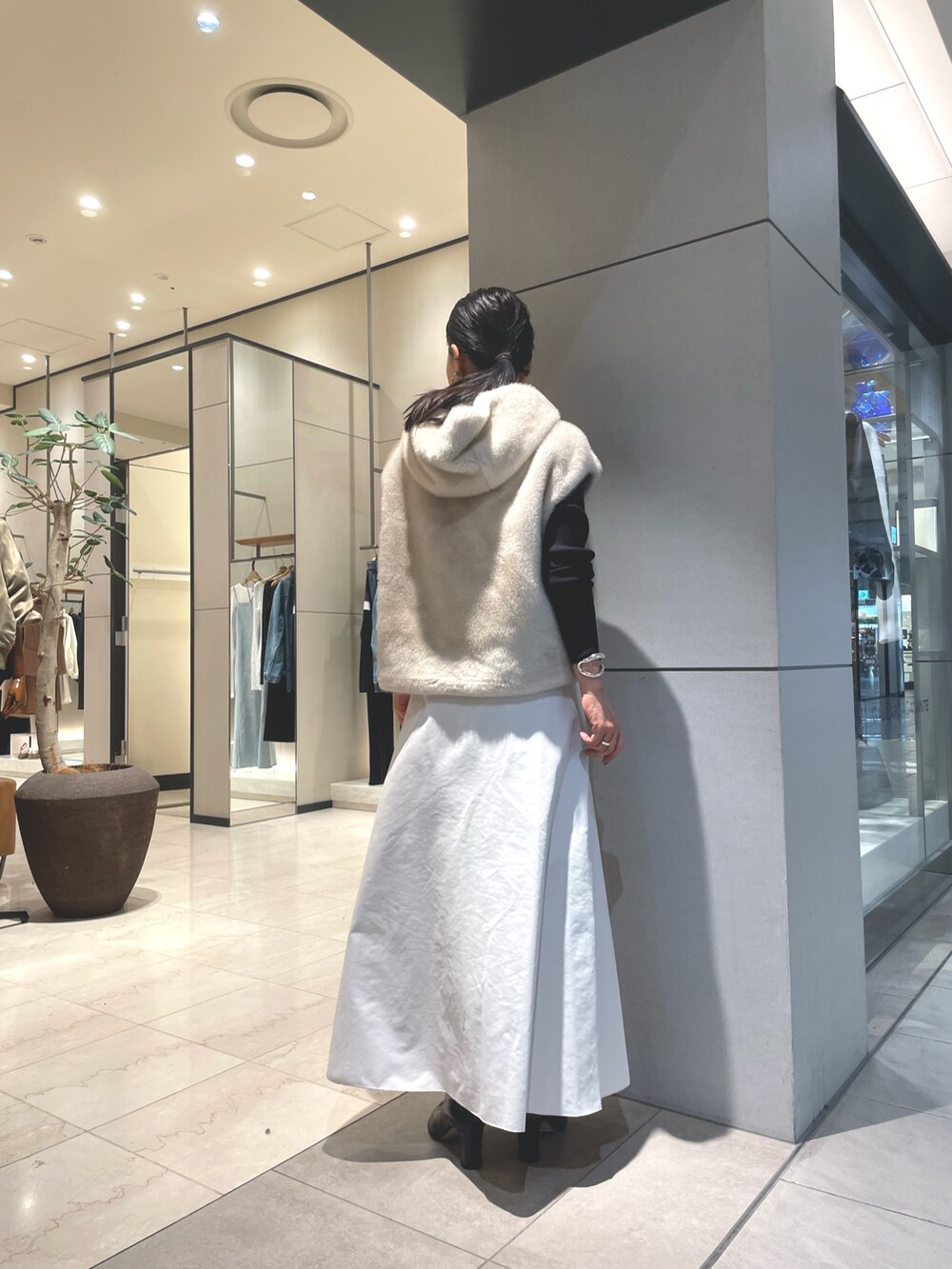 ベージュ系のスカート、ブラック系のブーツ、ブラック系のニット/セーターを着用したレディースの秋コーディネートの8枚目の写真