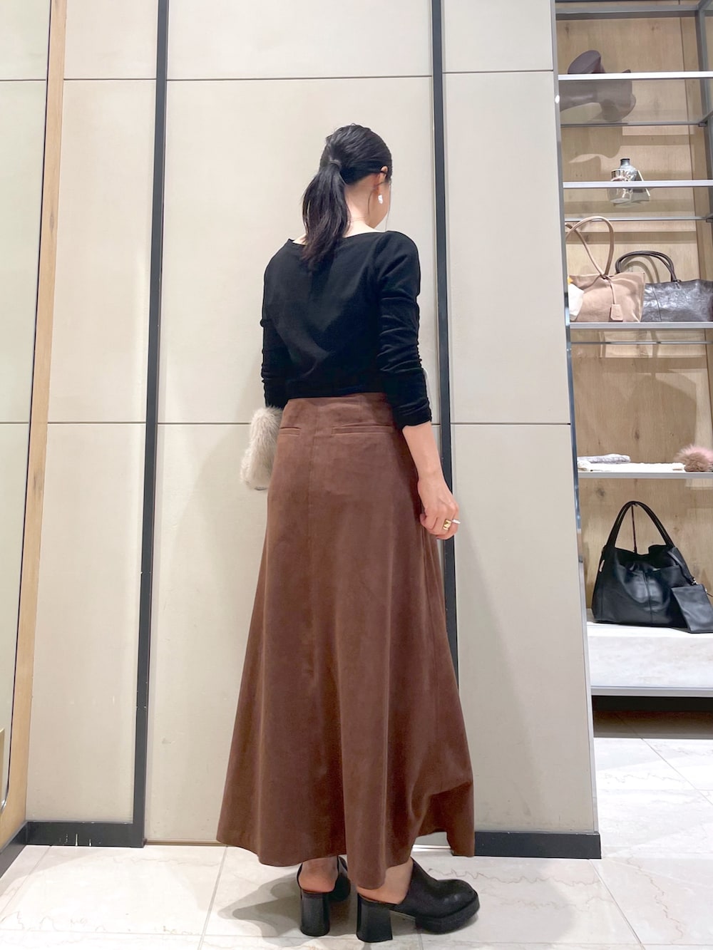 ブラック系のブーツ、ブラウン系のトートバッグ、ブラック系のTシャツ/カットソーを着用したレディースの秋コーディネートの5枚目の写真