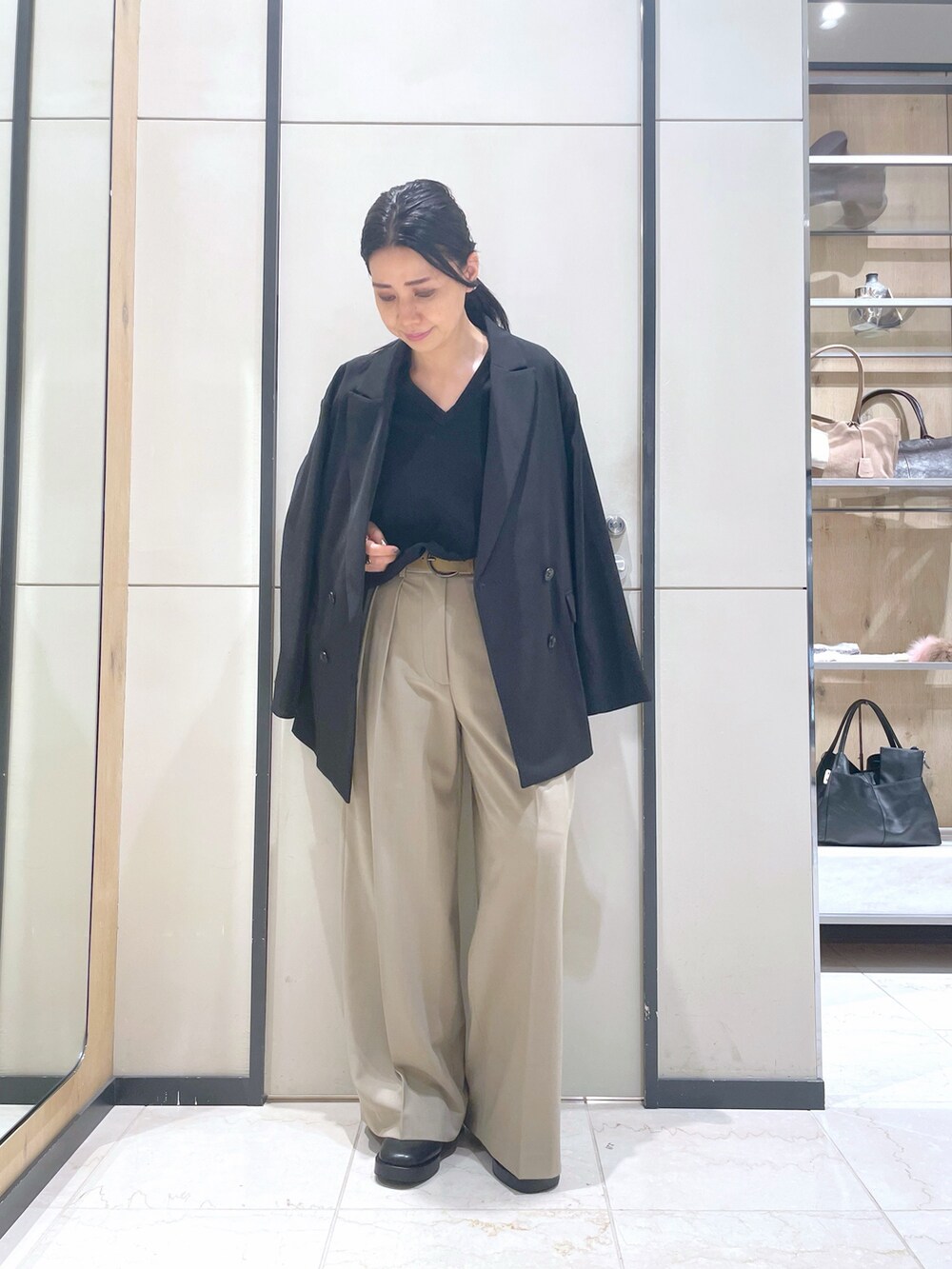 ブラック系のブーツ、ブラック系のベスト、ブラック系のテーラードジャケットを着用したレディースの秋コーディネートの8枚目の写真