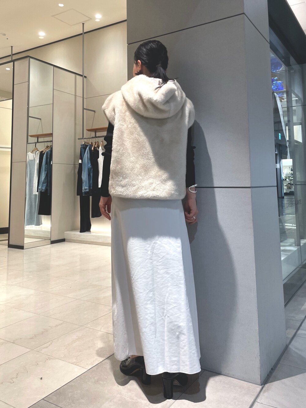 ベージュ系のスカート、ブラック系のブーツ、ブラック系のニット/セーターを着用したレディースの秋コーディネートの2枚目の写真