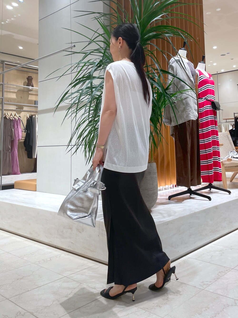 ブラック系のサンダル、シルバー系のトートバッグ、グレー系のスカートを着用したレディースの夏コーディネートの2枚目の写真
