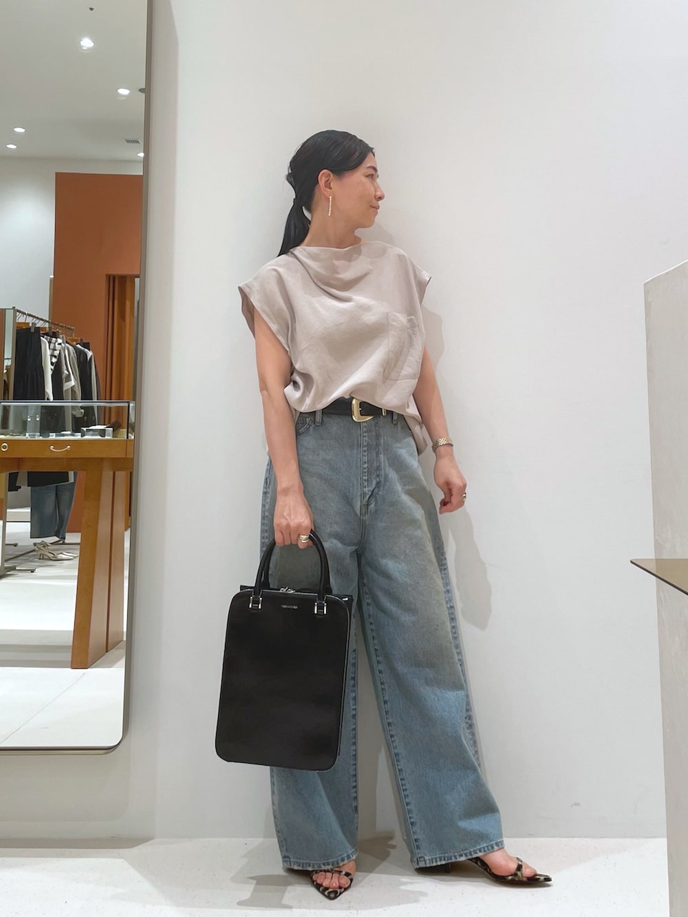 イエロー系のサンダル、ベージュ系のシャツ/ブラウス、ブルー系のデニムパンツを着用したレディースの夏コーディネートの5枚目の写真