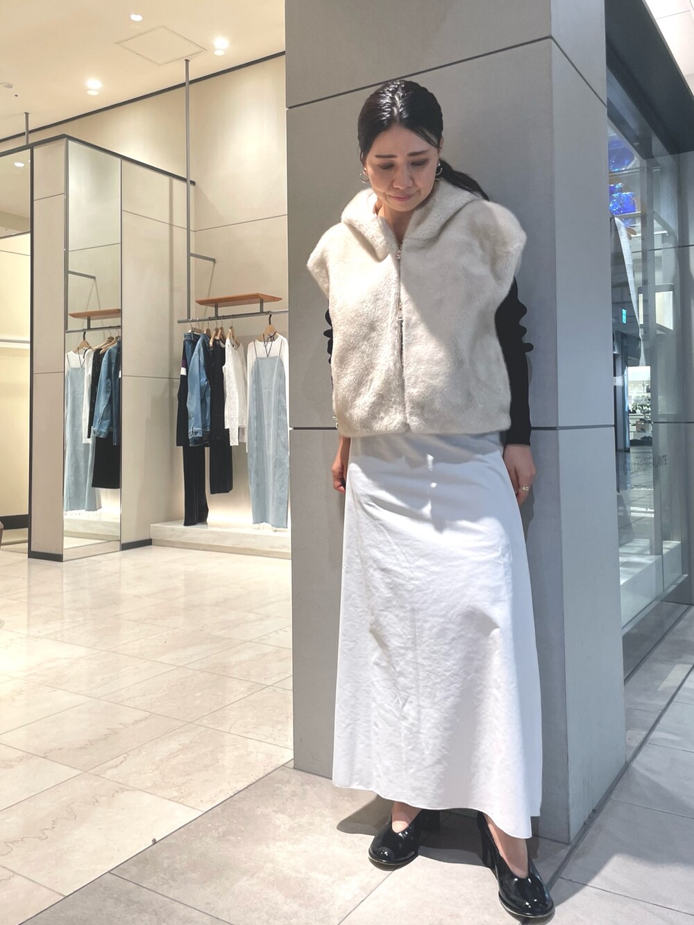 ベージュ系のスカート、ブラック系のブーツ、ブラック系のニット/セーターを着用したレディースの秋コーディネートの6枚目の写真