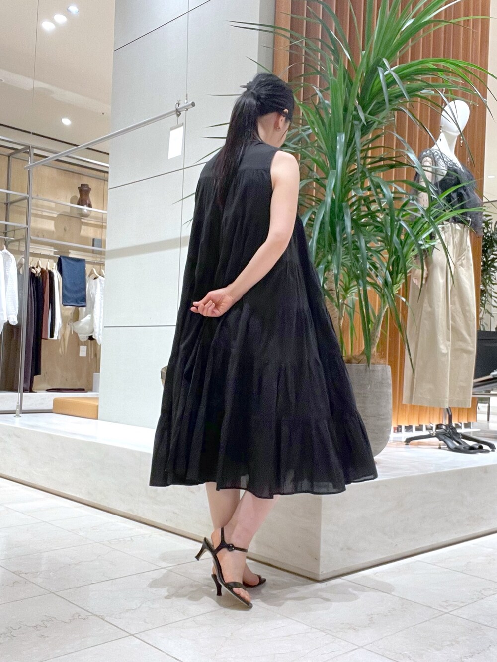 ブラック系のワンピース、ブラック系のサンダル、ブルー系のシャツ/ブラウスを着用したレディースの春コーディネートの6枚目の写真