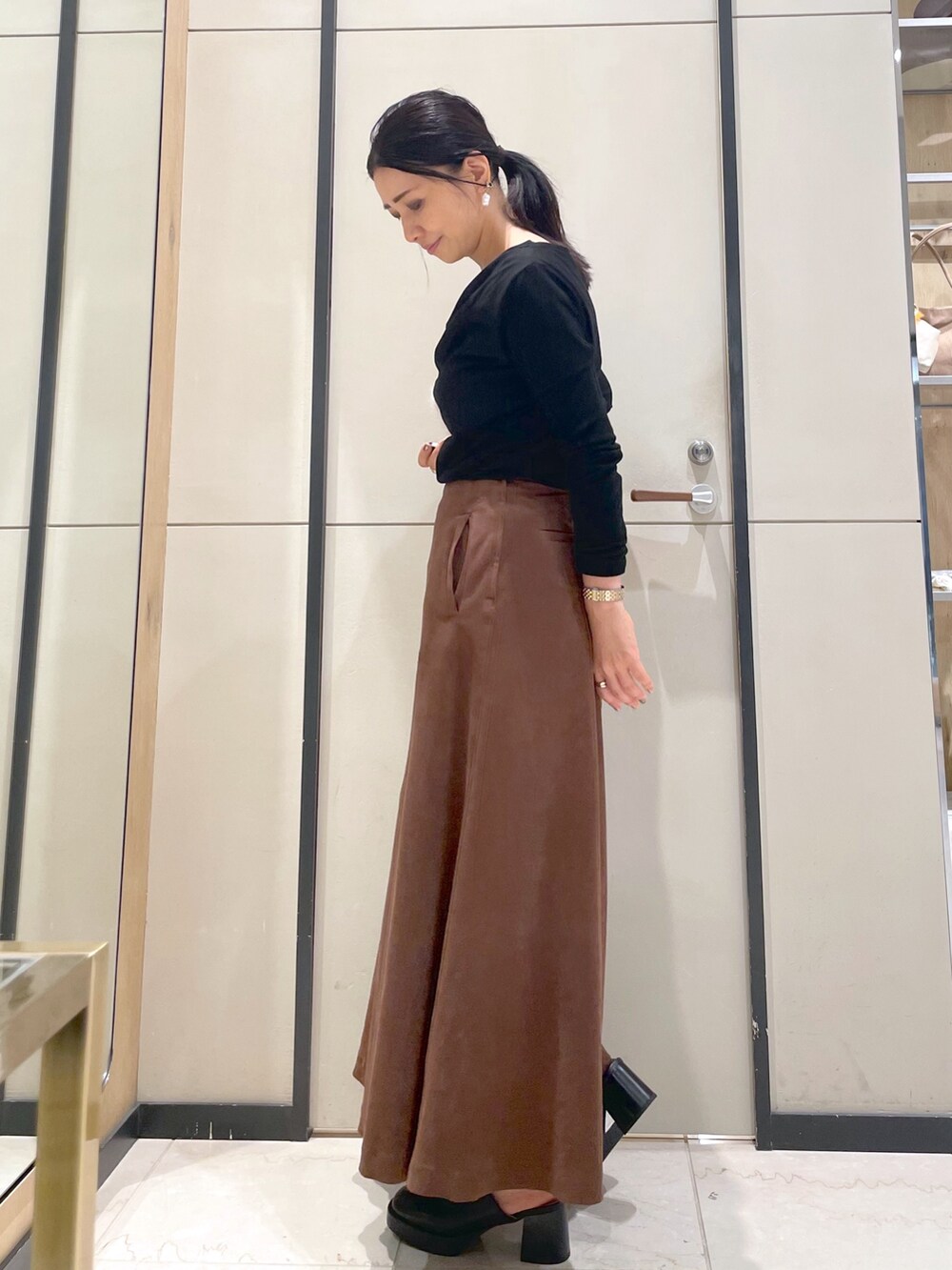 ブラック系のブーツ、ブラウン系のトートバッグ、ブラック系のTシャツ/カットソーを着用したレディースの秋コーディネートの9枚目の写真