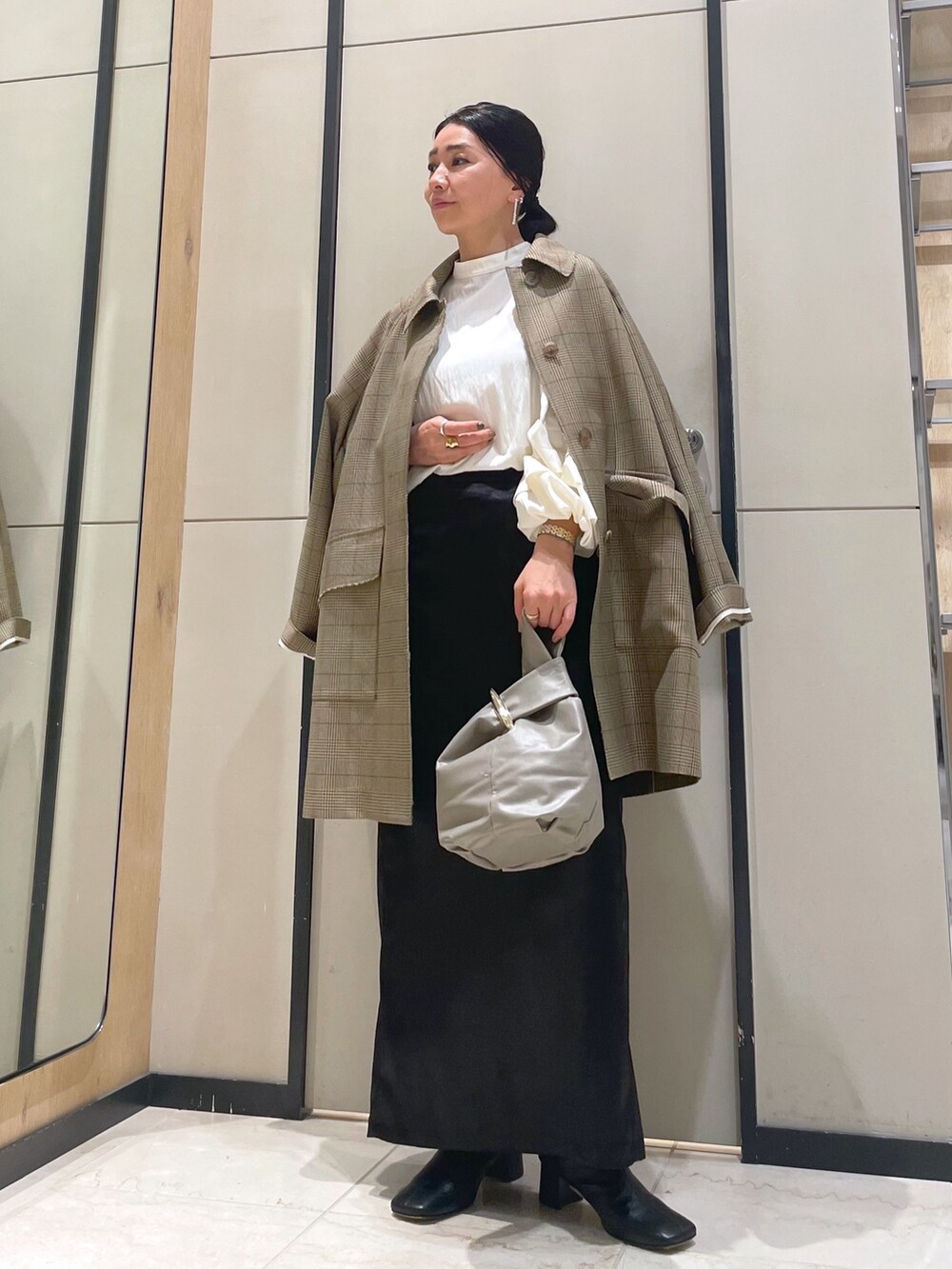 ホワイト系のシャツ/ブラウス、イエロー系のその他アウター、ベージュ系のトートバッグを着用したレディースの冬コーディネートの7枚目の写真