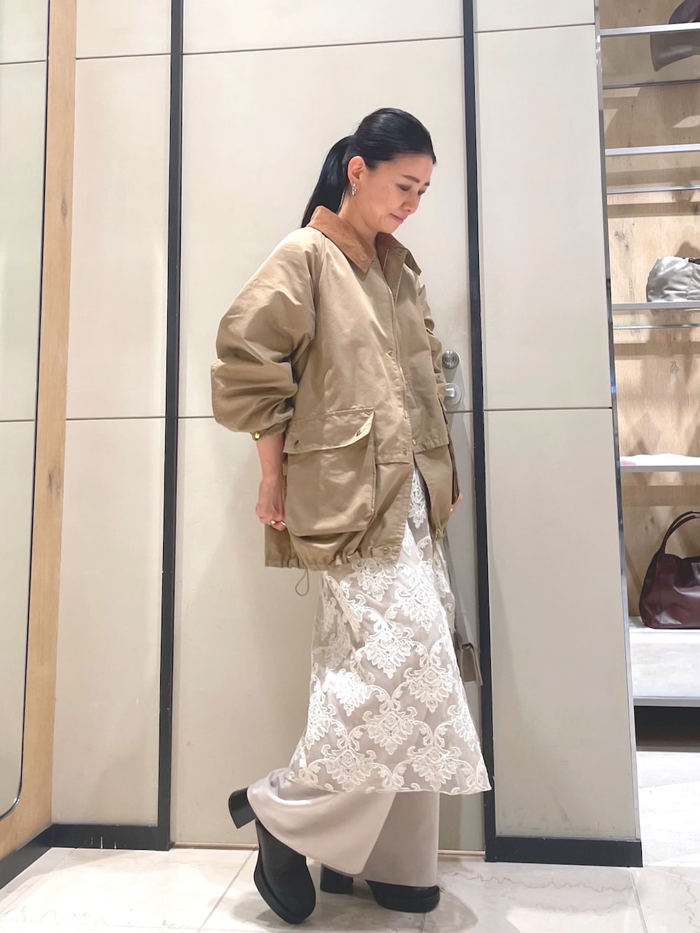 ブラック系のブーツ、ベージュ系のその他アウター、ベージュ系のその他パンツを着用したレディースの秋コーディネートの6枚目の写真