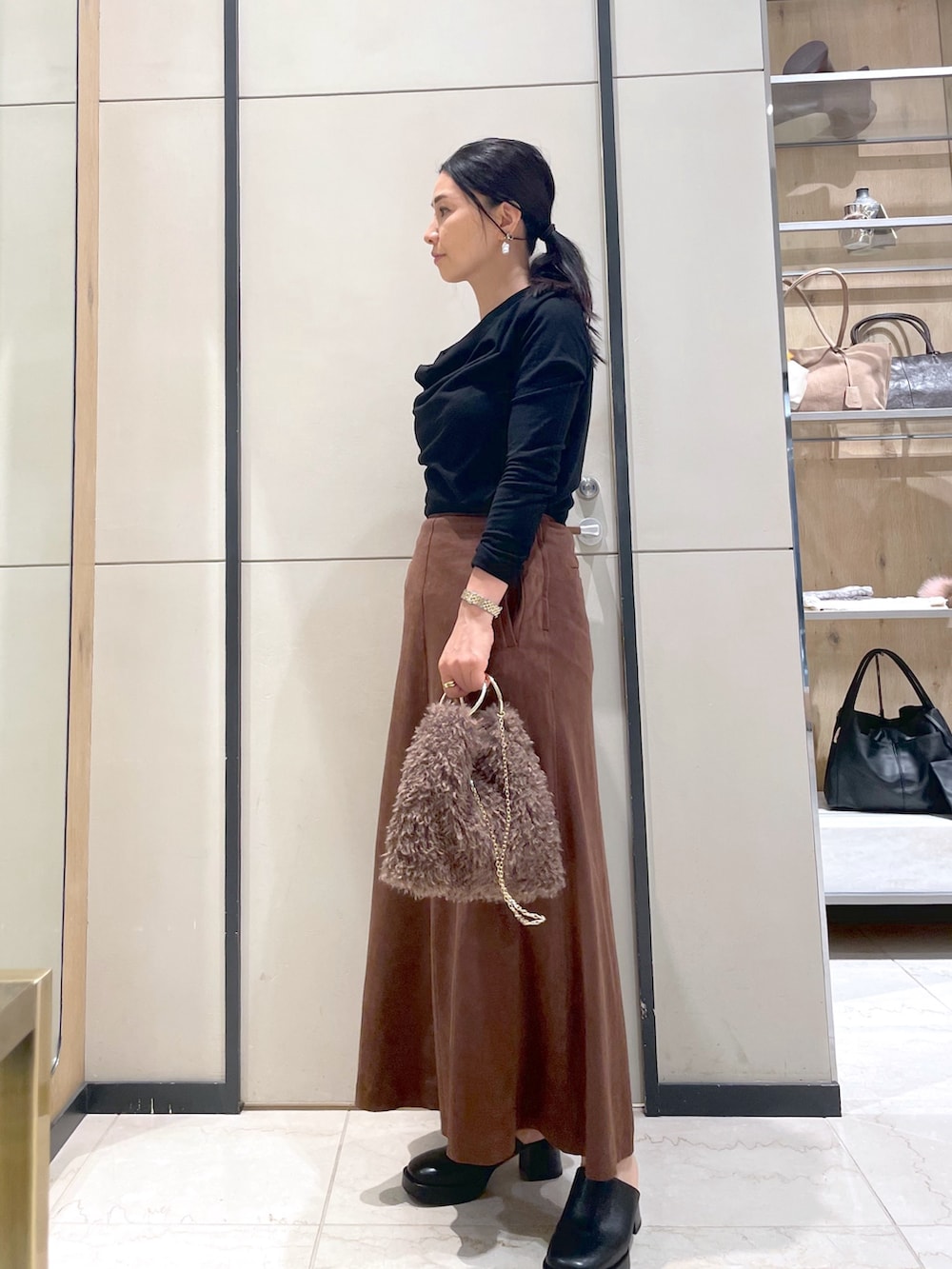 ブラック系のブーツ、ブラウン系のトートバッグ、ブラック系のTシャツ/カットソーを着用したレディースの秋コーディネートの2枚目の写真