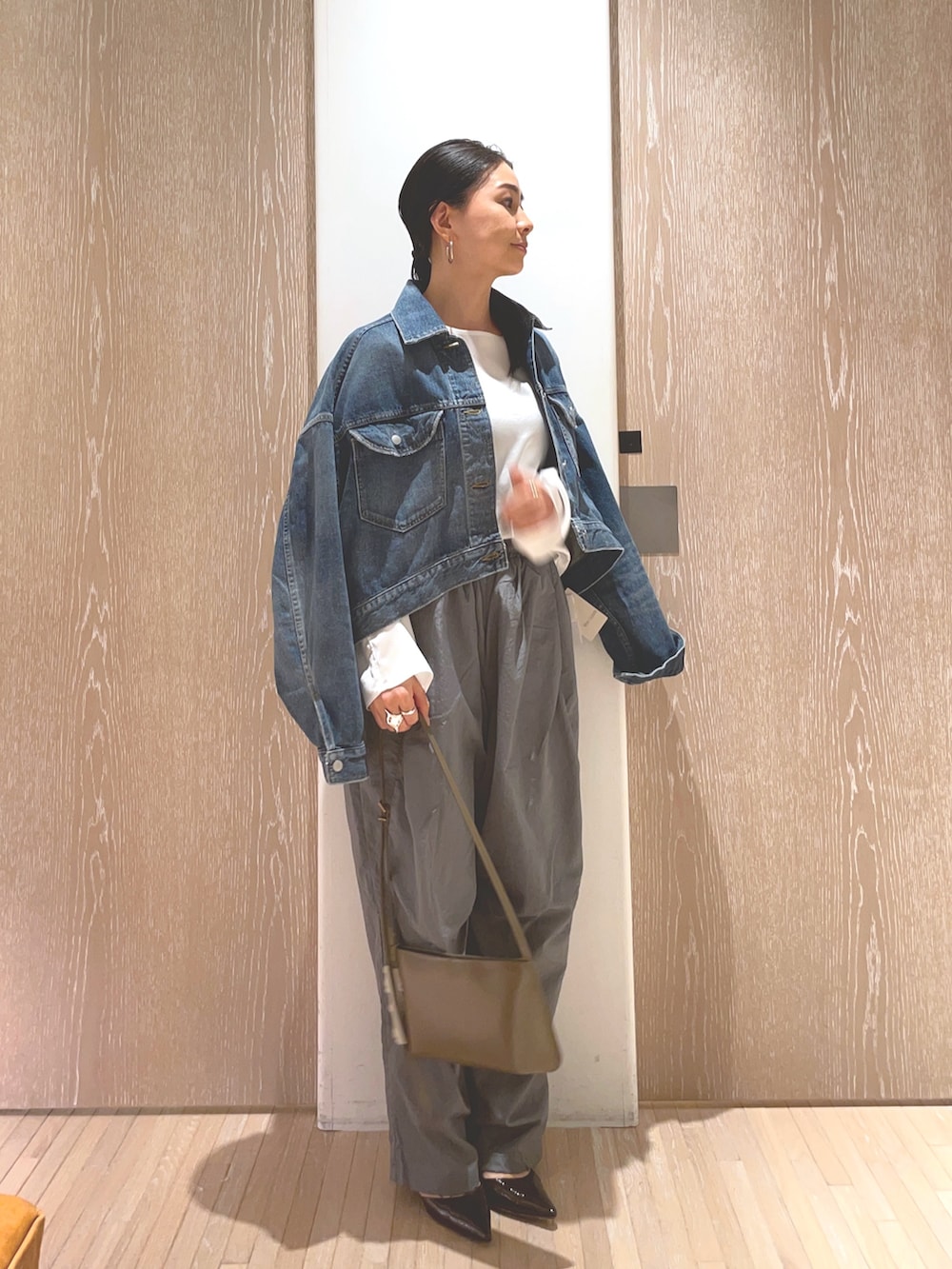 グレー系のその他パンツ、ブルー系のデニムジャケット、ブラウン系のショルダーバッグを着用したレディースの冬コーディネートの3枚目の写真