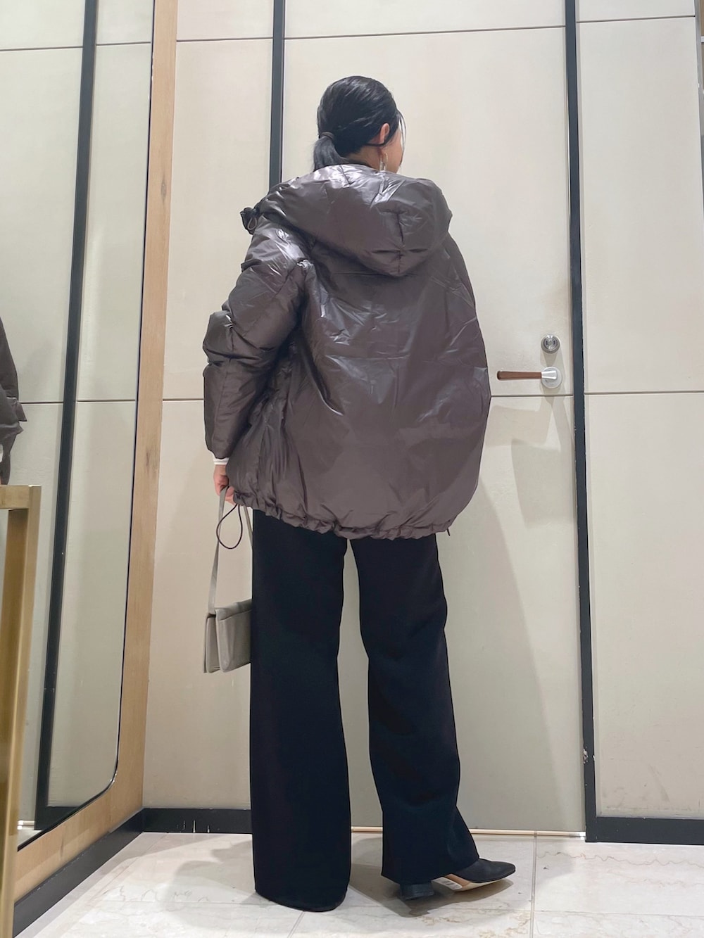 ブラック系のその他パンツ、ホワイト系のニット/セーター、ブラウン系のダウンジャケット/コートを着用したレディースの秋コーディネートの5枚目の写真