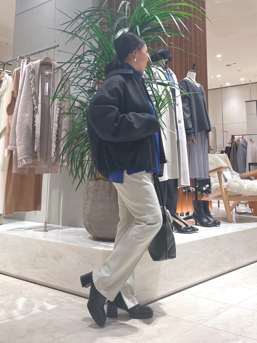 グレー系のその他アウター、ブルー系のニット/セーター、ブラック系のトートバッグを着用したレディースの秋コーディネートの5枚目の写真