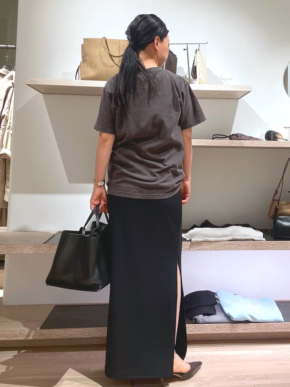 グレー系のTシャツ/カットソー、ブラウン系のパンプス、ブラック系のスカートを着用したレディースの春コーディネートの2枚目の写真