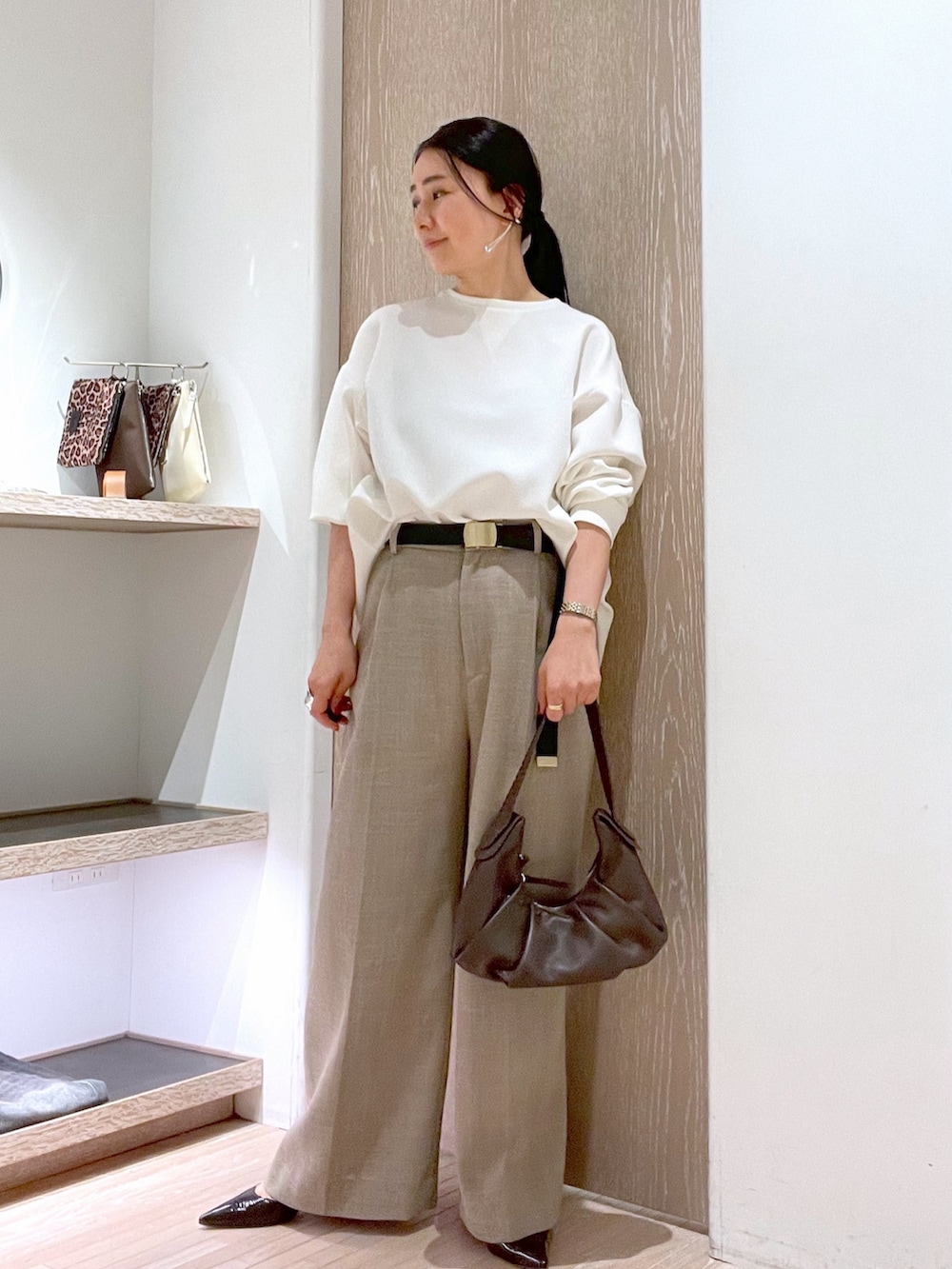 ブラウン系のトートバッグ、ブラウン系のパンプス、ホワイト系のシャツ/ブラウスを着用したレディースの春コーディネートの5枚目の写真