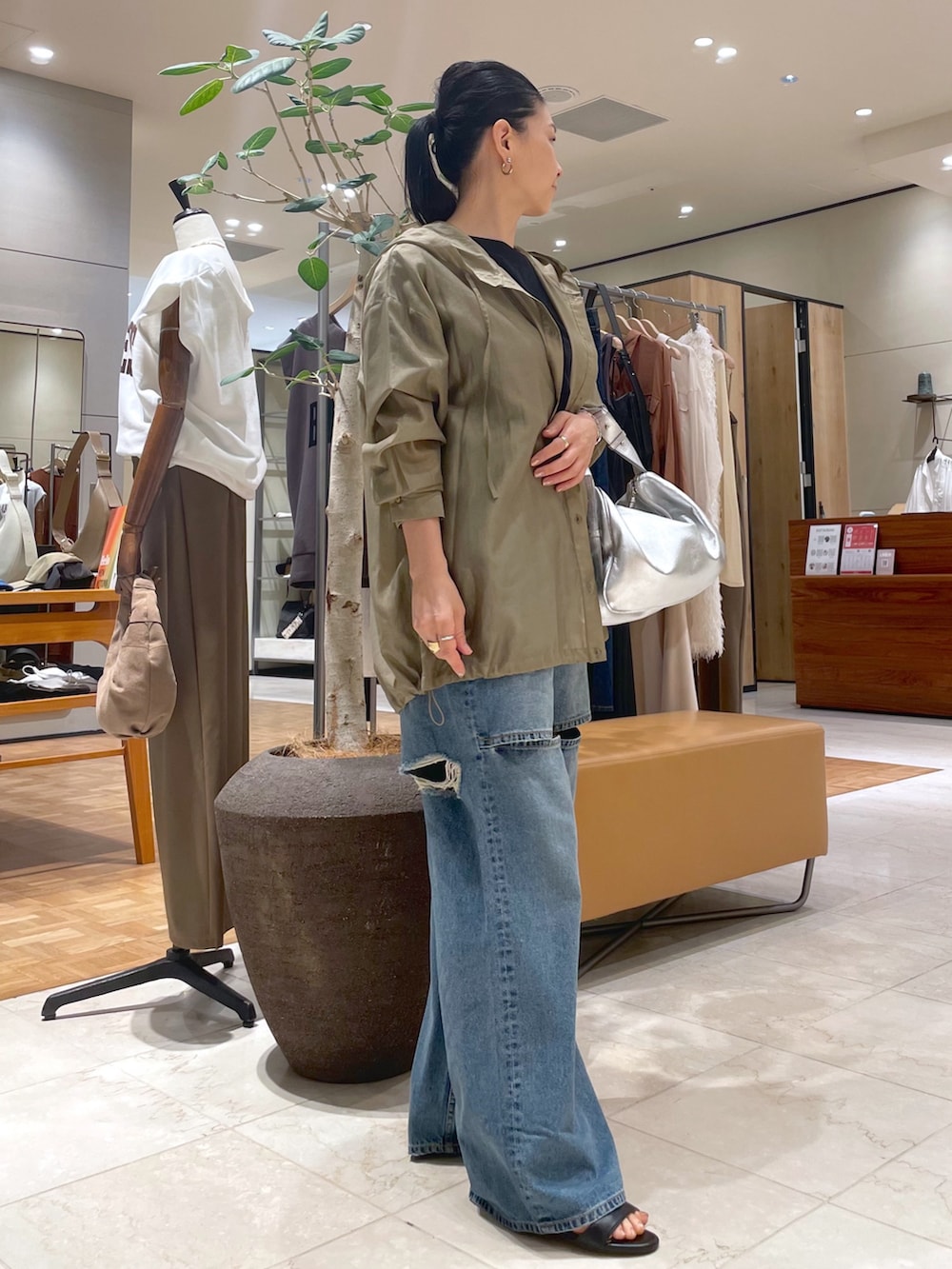 ブルー系のデニムパンツ、ベージュ系のシャツ/ブラウス、ブラック系のTシャツ/カットソーを着用したレディースの秋コーディネートの6枚目の写真