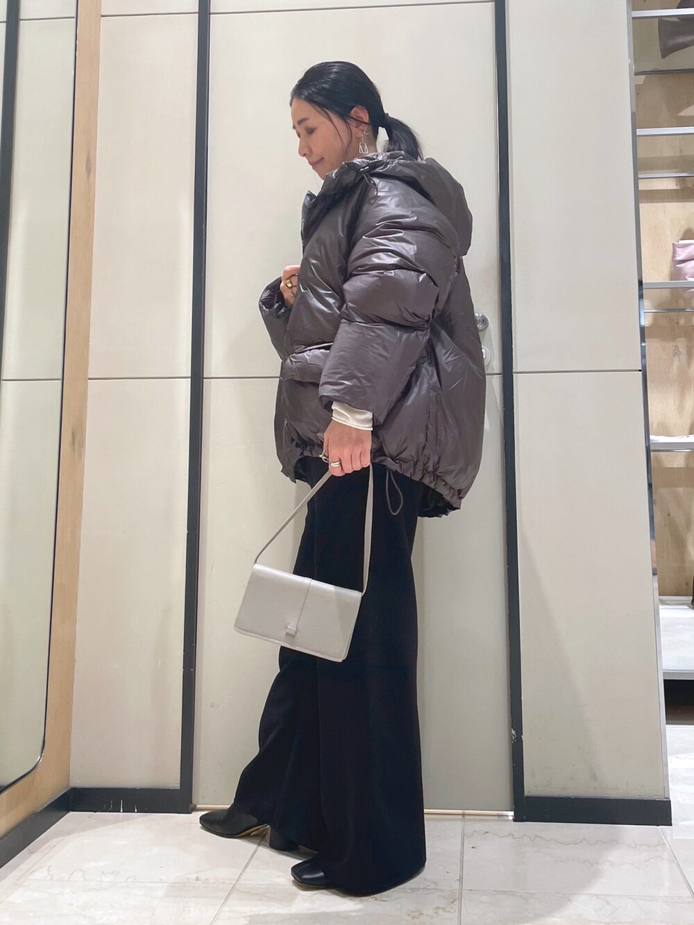 ブラック系のその他パンツ、ホワイト系のニット/セーター、ブラウン系のダウンジャケット/コートを着用したレディースの秋コーディネートの8枚目の写真