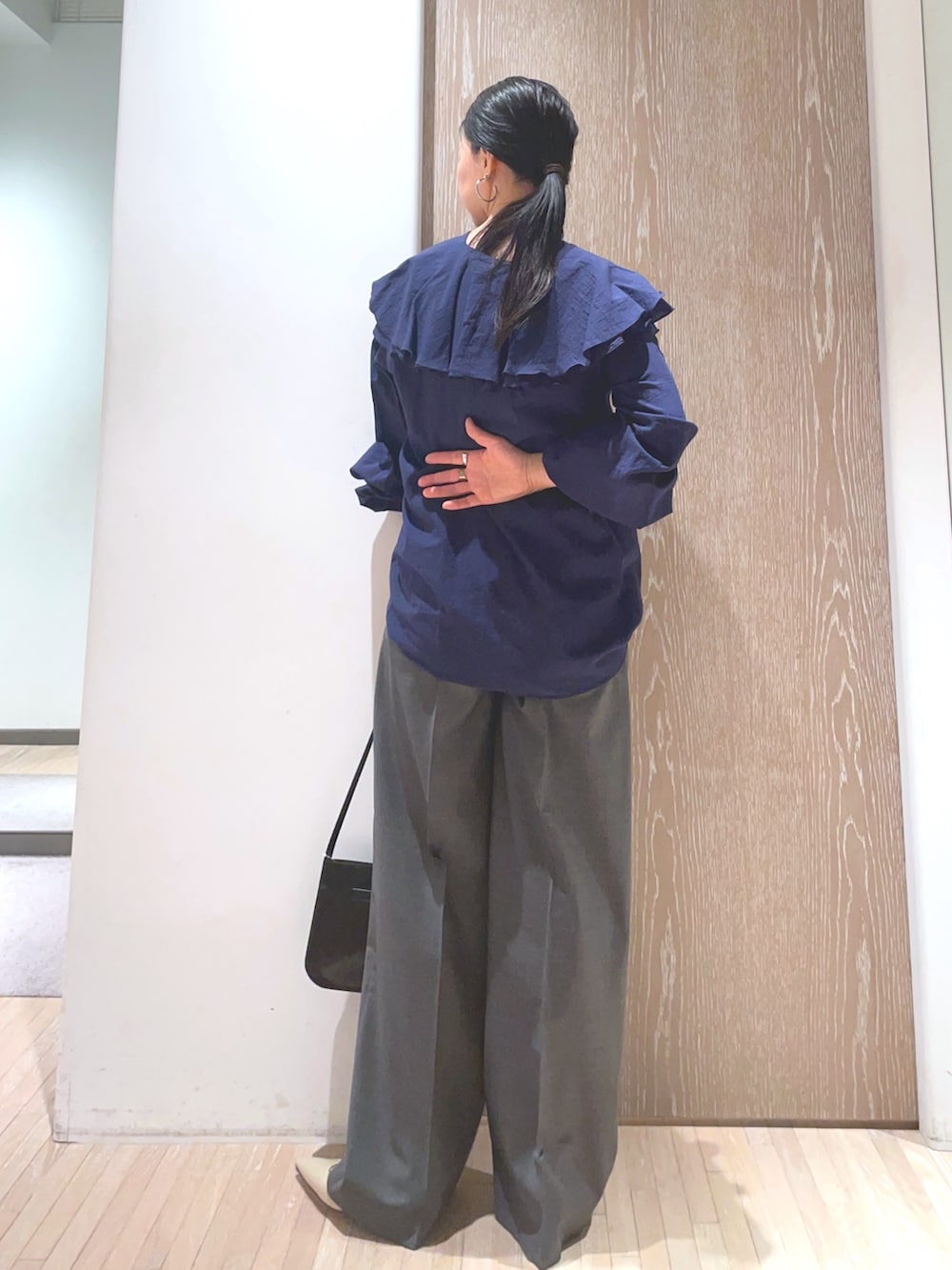 ブラック系のショルダーバッグ、ベージュ系のパンプス、ブルー系のシャツ/ブラウスを着用したレディースの冬コーディネートの2枚目の写真