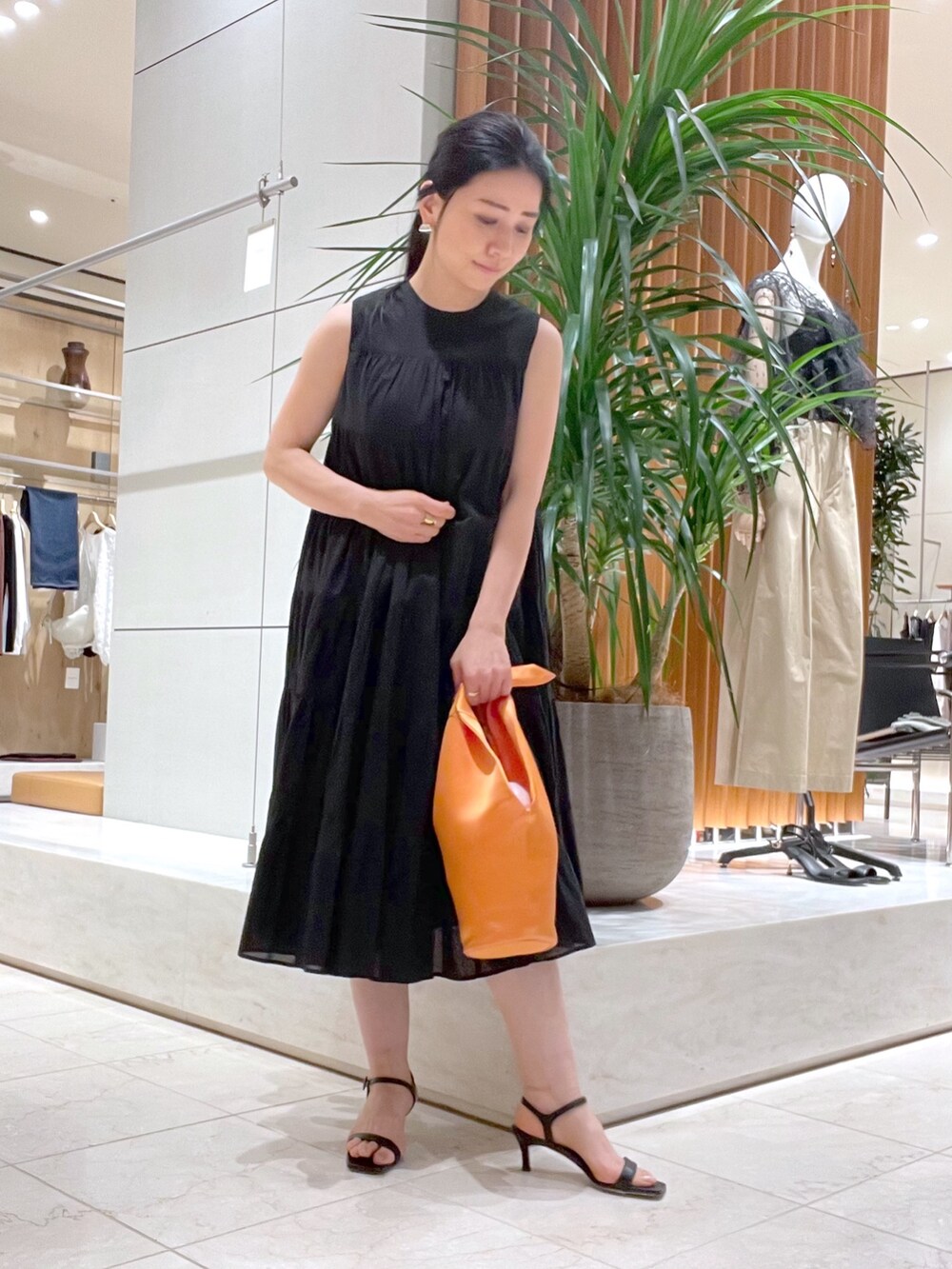 ブラック系のワンピース、ブラック系のサンダル、ブルー系のシャツ/ブラウスを着用したレディースの春コーディネートの7枚目の写真