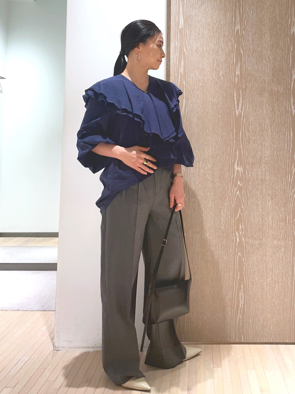 ブラック系のショルダーバッグ、ベージュ系のパンプス、ブルー系のシャツ/ブラウスを着用したレディースの冬コーディネートの3枚目の写真