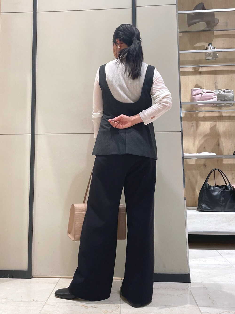ブラック系のその他パンツ、ホワイト系のニット/セーター、ブラウン系のダウンジャケット/コートを着用したレディースの秋コーディネートの10枚目の写真