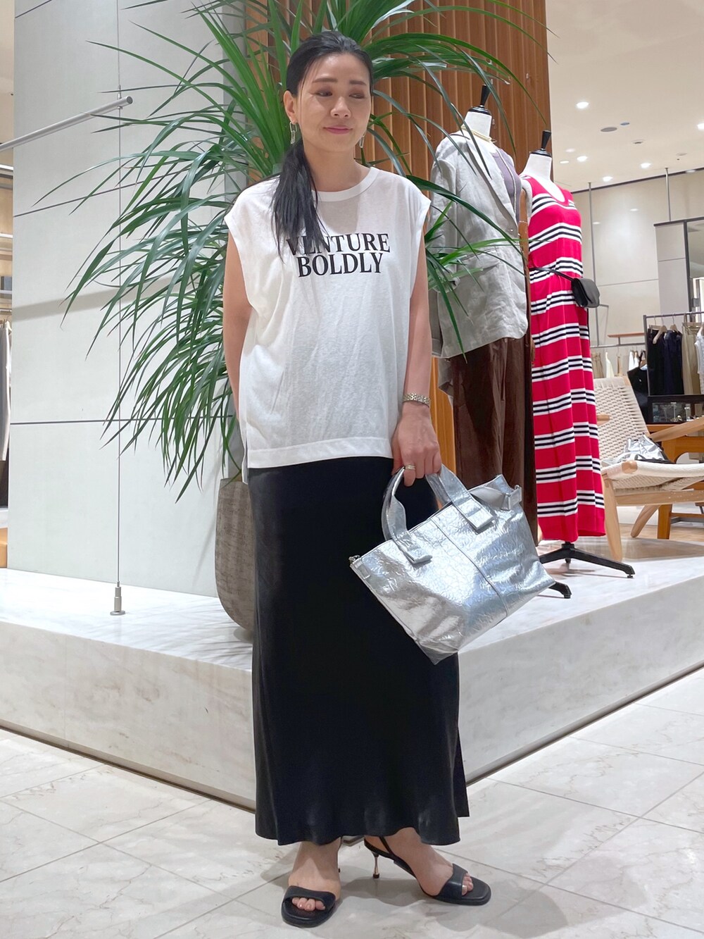 ブラック系のサンダル、シルバー系のトートバッグ、グレー系のスカートを着用したレディースの夏コーディネートの5枚目の写真