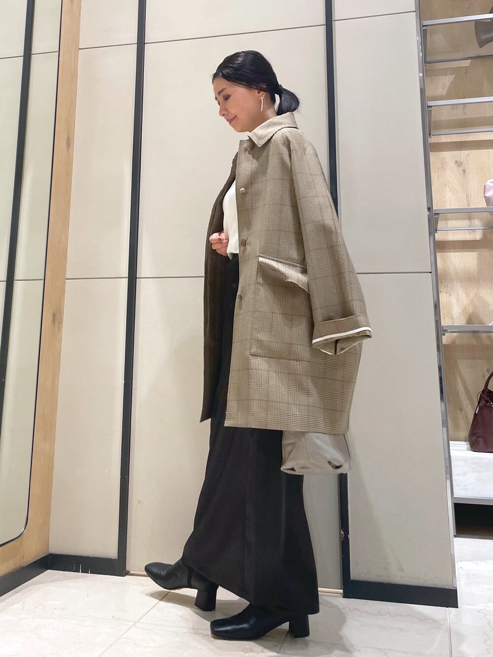 ホワイト系のシャツ/ブラウス、イエロー系のその他アウター、ベージュ系のトートバッグを着用したレディースの冬コーディネートの4枚目の写真