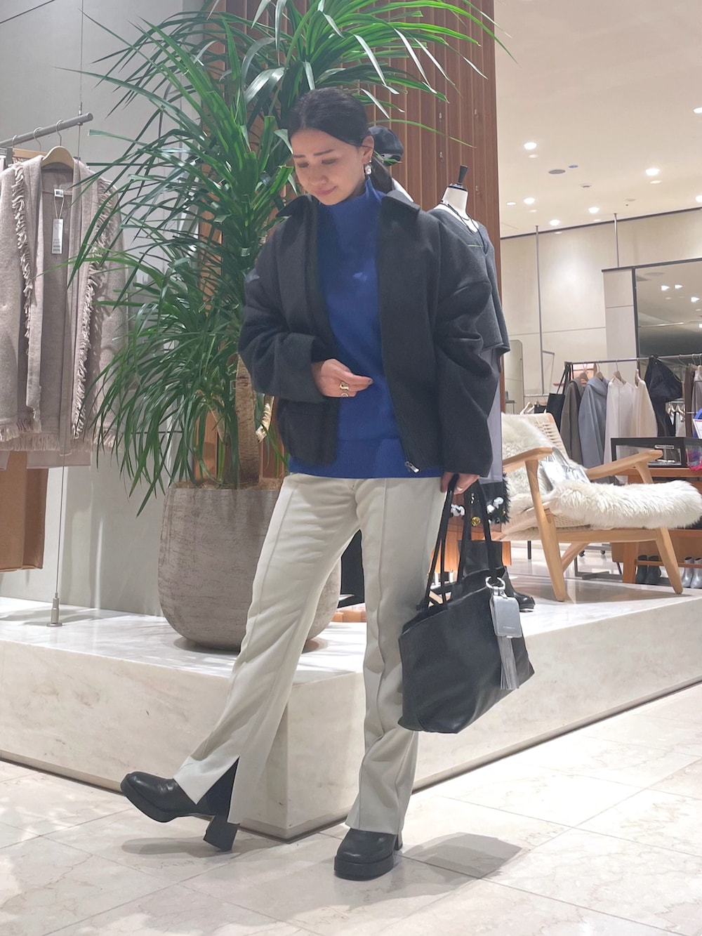 グレー系のその他アウター、ブルー系のニット/セーター、ブラック系のトートバッグを着用したレディースの秋コーディネートの6枚目の写真