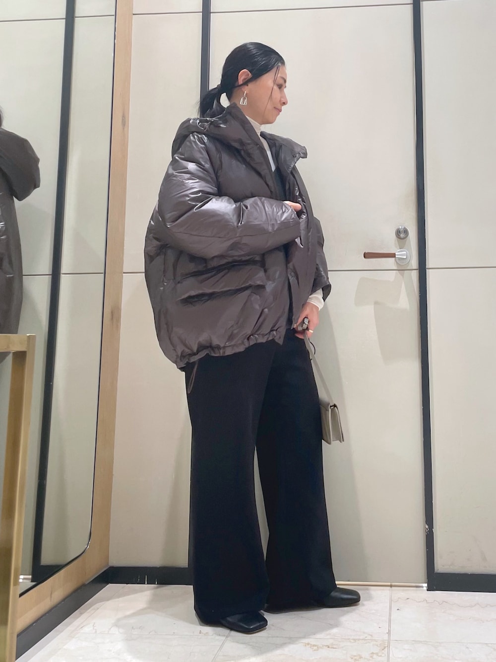 ブラック系のその他パンツ、ホワイト系のニット/セーター、ブラウン系のダウンジャケット/コートを着用したレディースの秋コーディネートの3枚目の写真