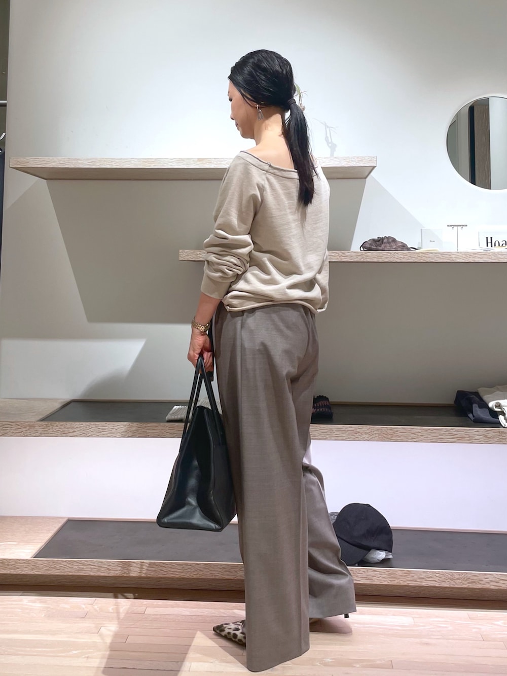 ベージュ系のスウェット、イエロー系のパンプス、ブラック系のボストンバッグを着用したレディースの春コーディネートの2枚目の写真