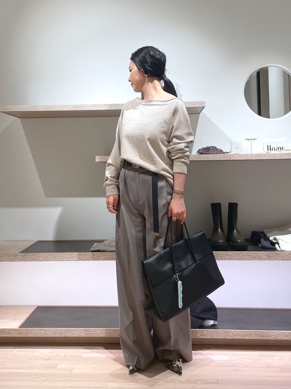 ベージュ系のスウェット、イエロー系のパンプス、ブラック系のボストンバッグを着用したレディースの春コーディネートの3枚目の写真