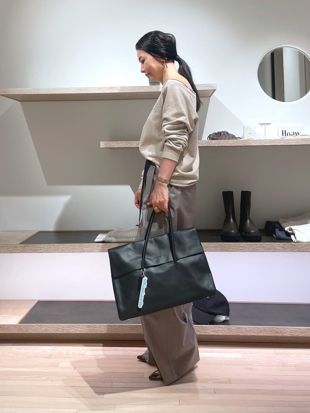 ベージュ系のスウェット、イエロー系のパンプス、ブラック系のボストンバッグを着用したレディースの春コーディネートの4枚目の写真