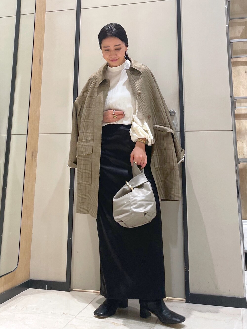 ホワイト系のシャツ/ブラウス、イエロー系のその他アウター、ベージュ系のトートバッグを着用したレディースの冬コーディネートの3枚目の写真