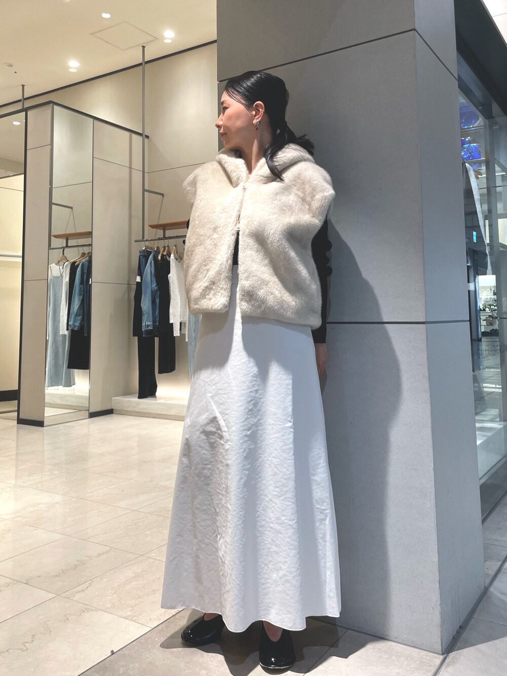 ベージュ系のスカート、ブラック系のブーツ、ブラック系のニット/セーターを着用したレディースの秋コーディネートの5枚目の写真