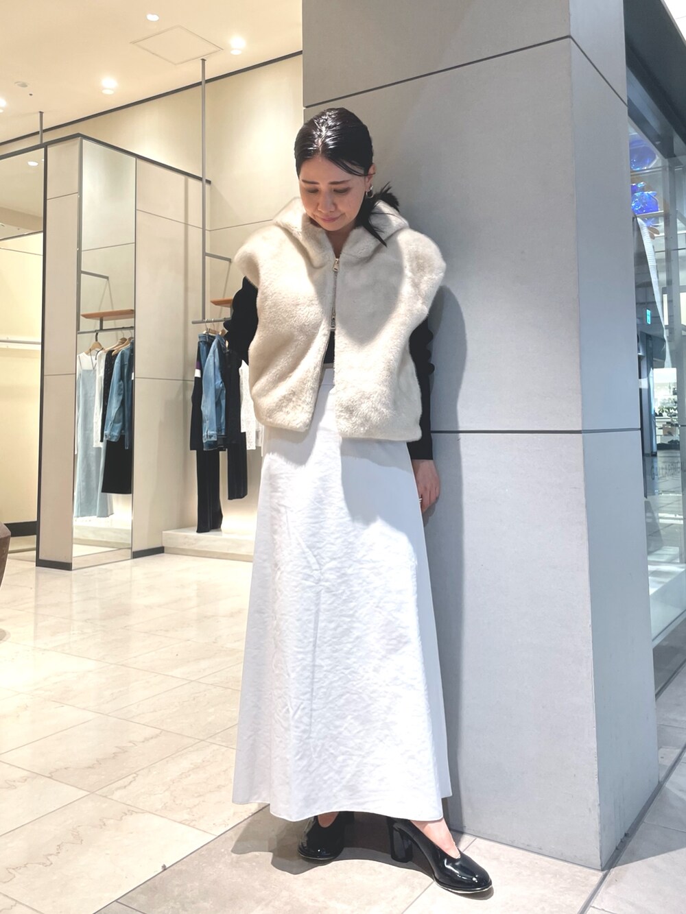 ベージュ系のスカート、ブラック系のブーツ、ブラック系のニット/セーターを着用したレディースの秋コーディネートの4枚目の写真