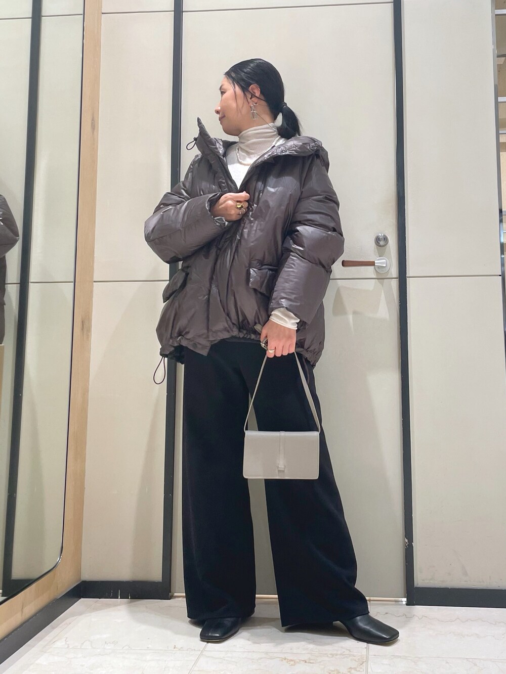 ブラック系のその他パンツ、ホワイト系のニット/セーター、ブラウン系のダウンジャケット/コートを着用したレディースの秋コーディネートの7枚目の写真