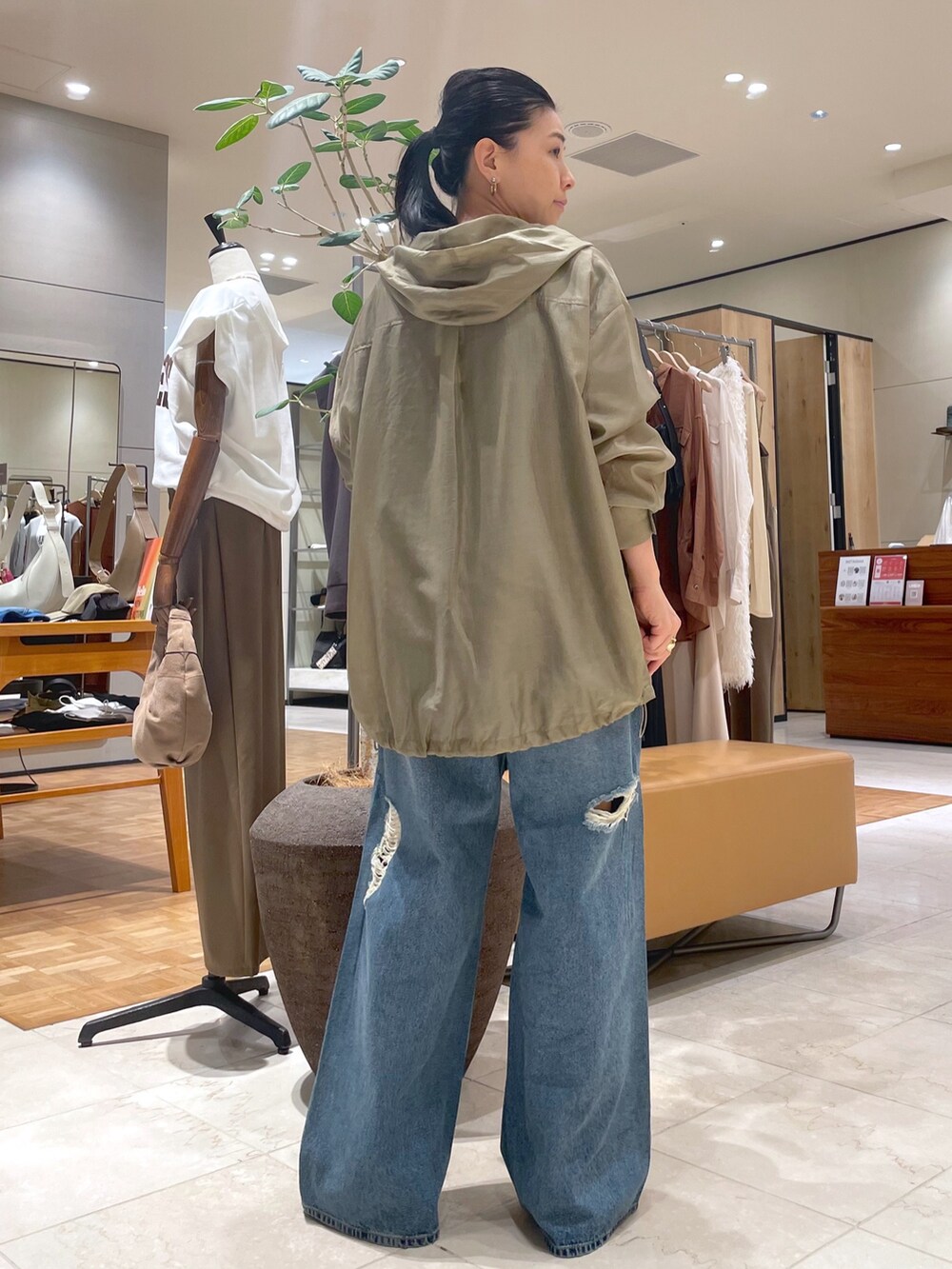 ブルー系のデニムパンツ、ベージュ系のシャツ/ブラウス、ブラック系のTシャツ/カットソーを着用したレディースの秋コーディネートの2枚目の写真