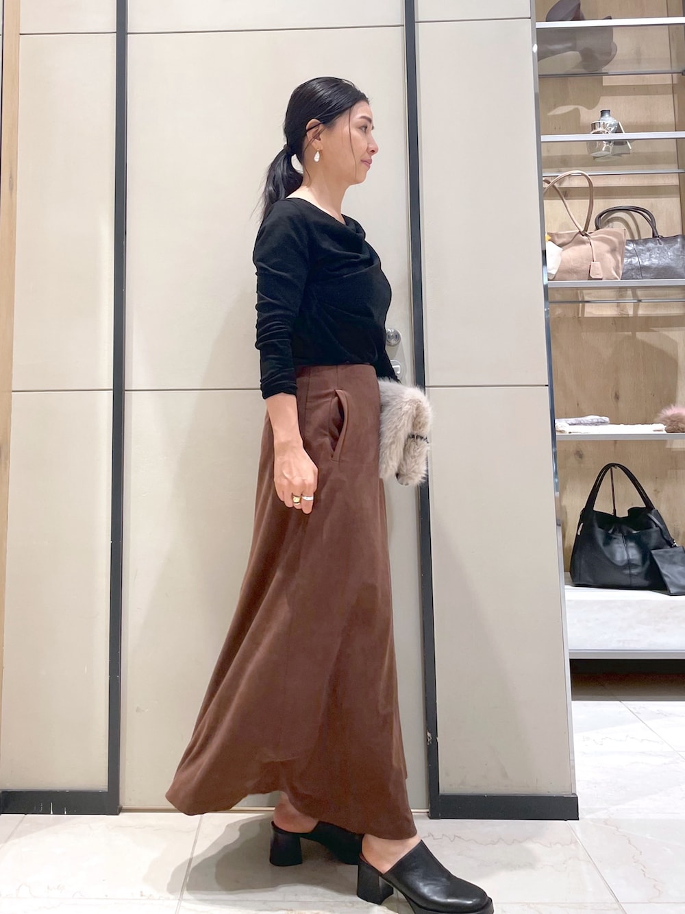 ブラック系のブーツ、ブラウン系のトートバッグ、ブラック系のTシャツ/カットソーを着用したレディースの秋コーディネートの4枚目の写真