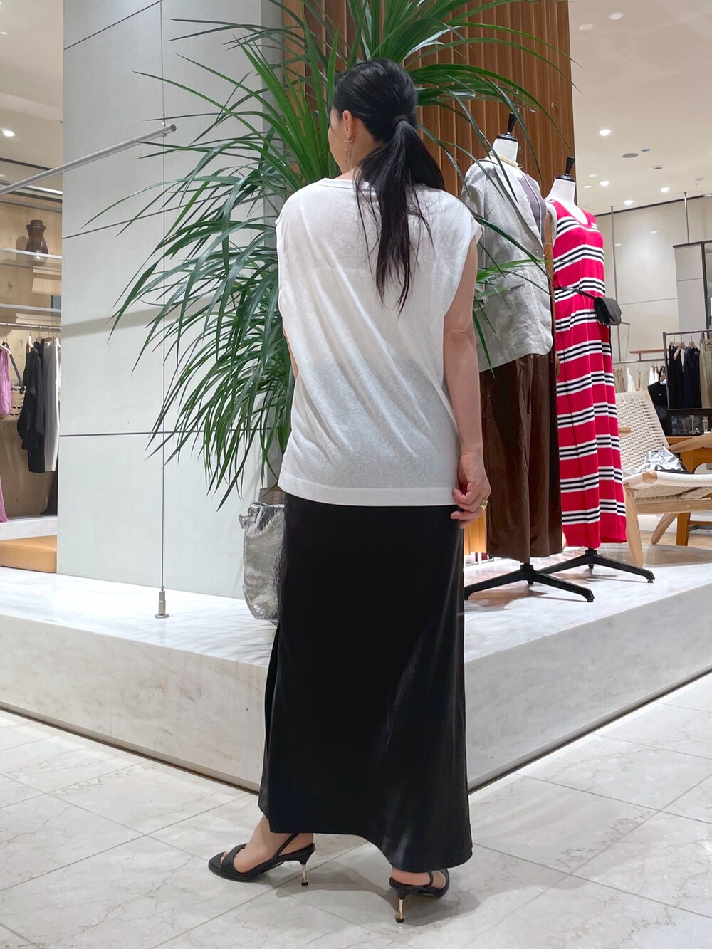 ブラック系のサンダル、シルバー系のトートバッグ、グレー系のスカートを着用したレディースの夏コーディネートの3枚目の写真