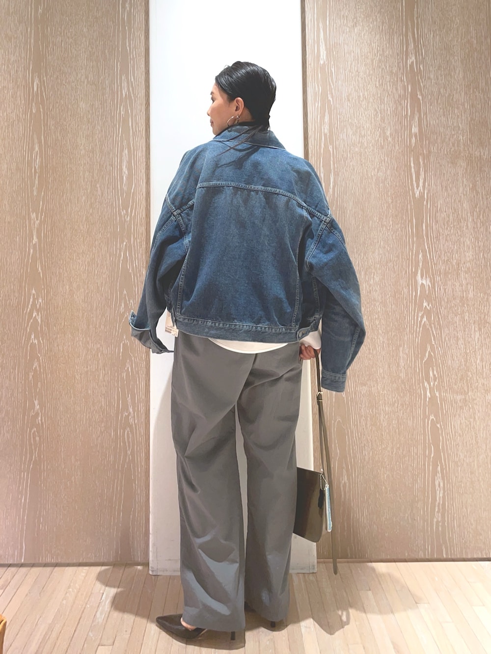 グレー系のその他パンツ、ブルー系のデニムジャケット、ブラウン系のショルダーバッグを着用したレディースの冬コーディネートの2枚目の写真