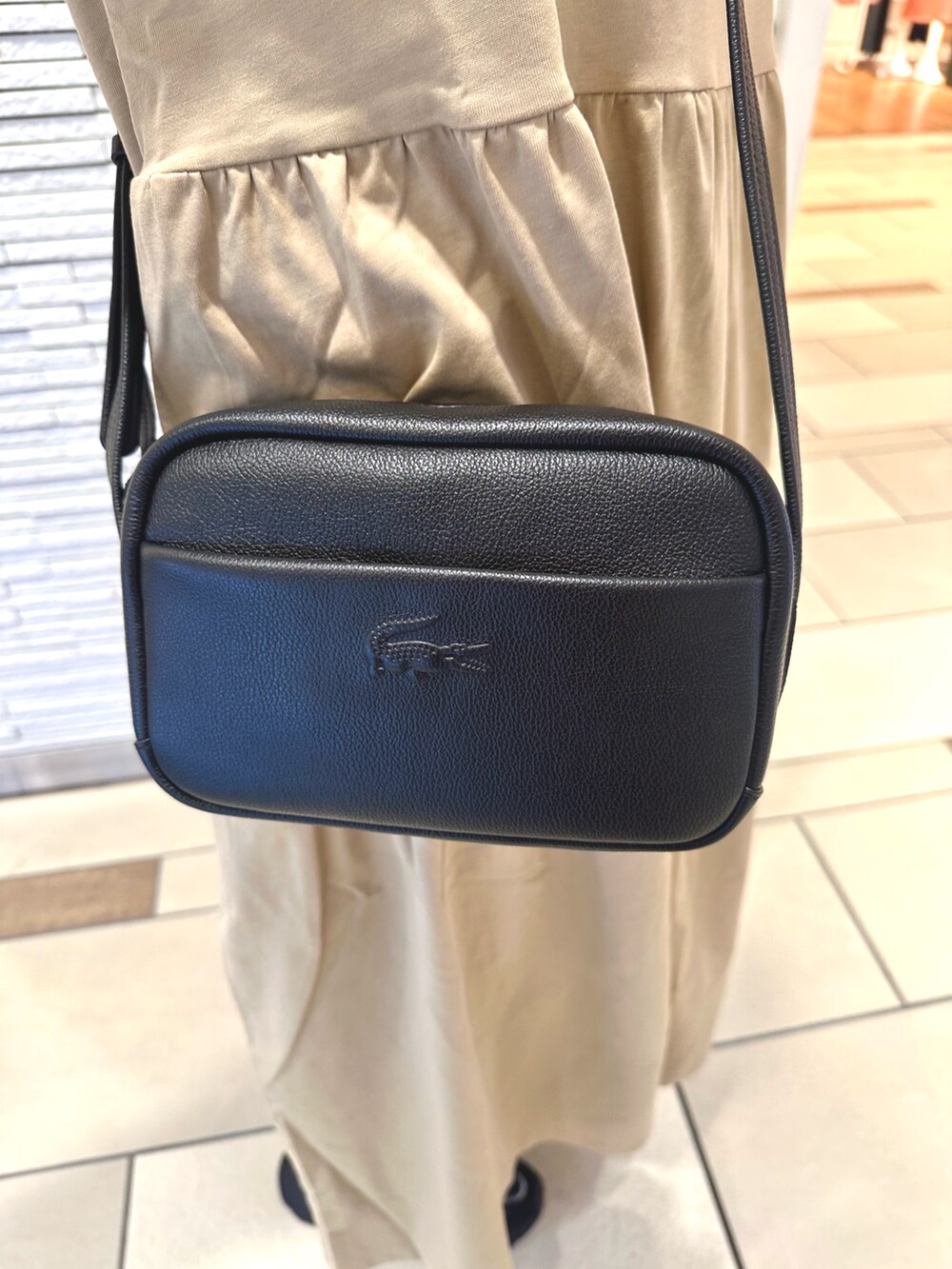 ベージュ系のワンピース、ブラック系のカーディガン/ボレロ、ブラック系のショルダーバッグを着用したレディースの夏コーディネートの5枚目の写真